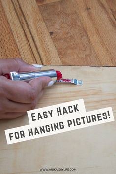 a person is holding an object with the words easy hack for hanging pictures