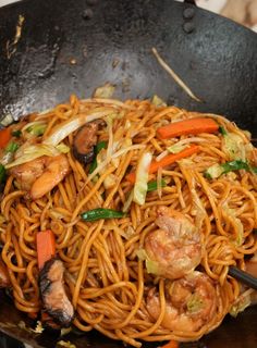 stir fry noodles with shrimp and vegetables in a wok