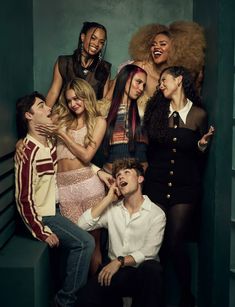 a group of people posing for a photo in front of a green wall with their mouths open