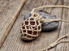 a rock with a string wrapped around it sitting on top of a wooden table next to a stone