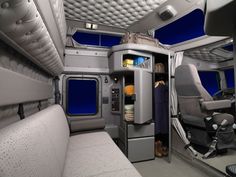 the interior of an airplane with seats and shelves on each side, including one door open