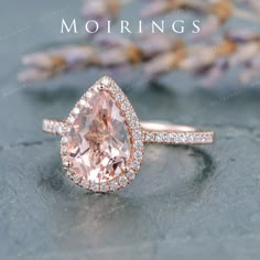 an engagement ring with a pear shaped morganite in the center and diamonds around it