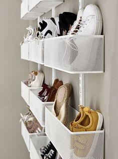 several pairs of shoes are hanging on the wall in this shoe storage rack with mesh bins