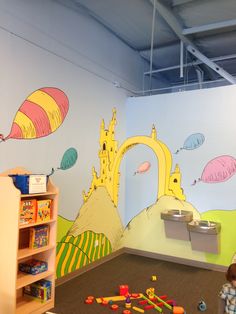 a child's playroom with toys and artwork on the walls