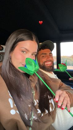 a man and woman sitting in the back of a car with paper flowers on it