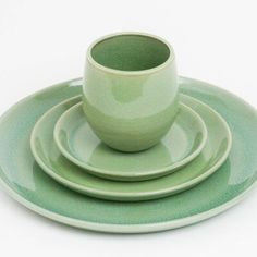 a stack of green plates and cups on top of each other