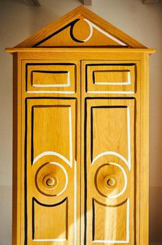 a wooden cabinet with two doors that are carved into the top and bottom part of it