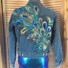 a denim jacket with sequins and peacock feathers on it