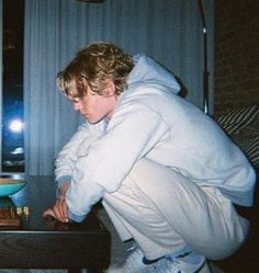 a person in a white hoodie leaning over a table