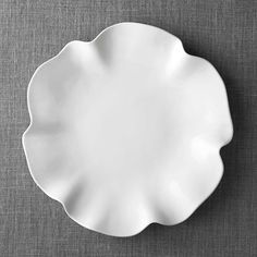 an empty white plate sitting on top of a table