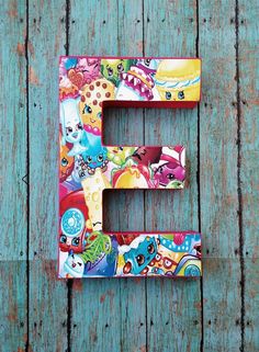 the letter e is made up of cartoon characters and letters that are painted on wood