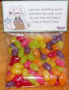 a bag filled with jelly beans sitting on top of a wooden table next to a sign