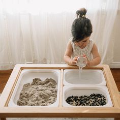 Create the feeling of a beach trip plus so much more, all within the comfort of your own home! Wonder & Wise's Sand and Water Table is a cleverly designed activity table that provides sensory stimulus as well as encourages gross and fine motor skills. With collapsible storage bins for sand, water and pebbles, your little one can enjoy different textures and create mini sand castles of their dreams. For less messy play, the table turns into a wooden train track, while the chalkboard panel provide Kinetic Sand Storage, Homeschool Vibes, Modern Daycare Design, Kinetic Sand Table, Daycare Design Ideas, Wooden Train Track, Daycare Design, Baby Table, Play Wood