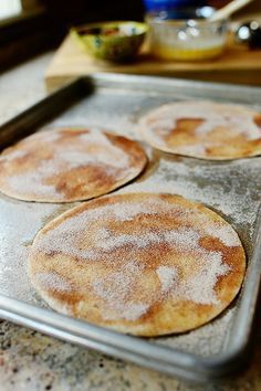 four pancakes sitting on top of a pan covered in powdered sugar