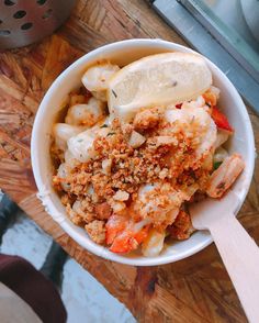 a white bowl filled with food on top of a wooden table