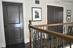 an entry way with two doors and pictures on the wall next to it's railing