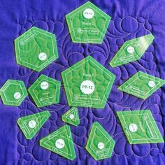 six green glass award plaques sitting on top of a purple quilt