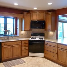 a kitchen with wooden cabinets and black appliances