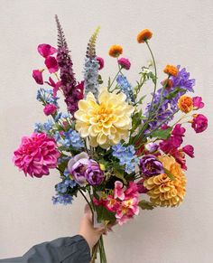 a person holding a bouquet of colorful flowers