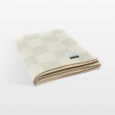 a white and beige checkered blanket folded on top of each other