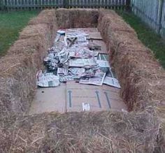 a large pile of hay sitting in the middle of a yard next to a fence