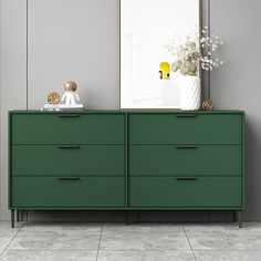 a green dresser sitting in front of a mirror