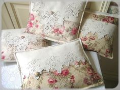 four pillows with lace and flowers on them