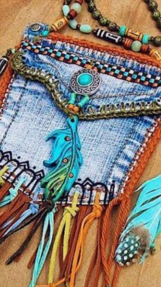 a blue purse with feathers and beads on it