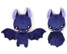 two stuffed animals that look like bats with big eyes and fangs on their wings, one is