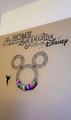 a wall with a mickey mouse design on it and the words home is where we live laughter, love lots of disney