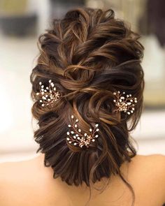 the back of a woman's head with hair pins in her hair and pearls on it