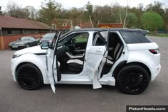 a white car with its door open in a parking lot