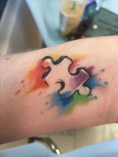 a person's arm with a colorful puzzle tattoo on it