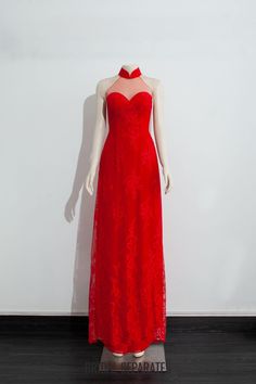 a mannequin wearing a red dress on display in front of a white wall