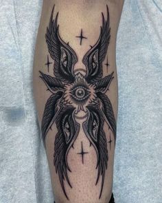 a man's leg with tattoos on it and an evil eye in the center