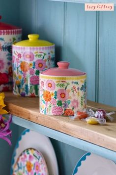 colorful floral canisters and plates on a shelf