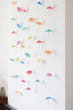 there are many umbrellas on the wall and one is made out of colored paper