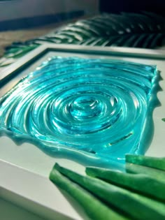 a close up of a blue glass plate on a table with green beans in it