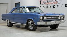 an old blue car is parked in a garage