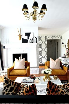 a living room with couches, chairs and a chandelier hanging from the ceiling