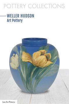 a blue vase with yellow flowers painted on it