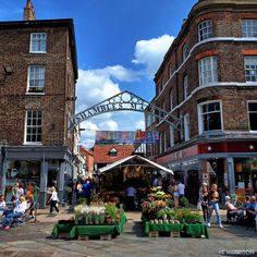 an outdoor market with lots of people walking around