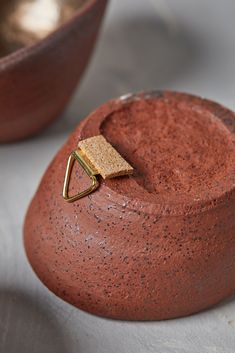 a close up of a clay pot with a gold ring on it's end