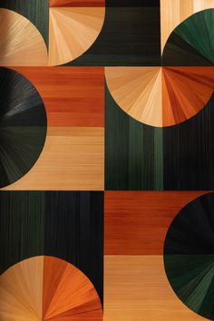 an abstract painting with different colors and shapes on the wood paneled wall in front of it