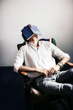 a man sitting in a chair with a hat on his head