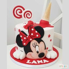 a minnie mouse birthday cake with red and white decorations