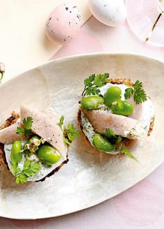 two open faced sandwiches are on a white plate