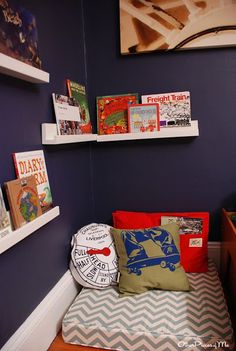 a child's bedroom with blue walls and bookshelves on the shelves above