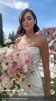 a woman in a white dress holding a bouquet of pink and white flowers on her wedding day