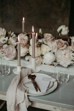 the table is set with flowers and candles